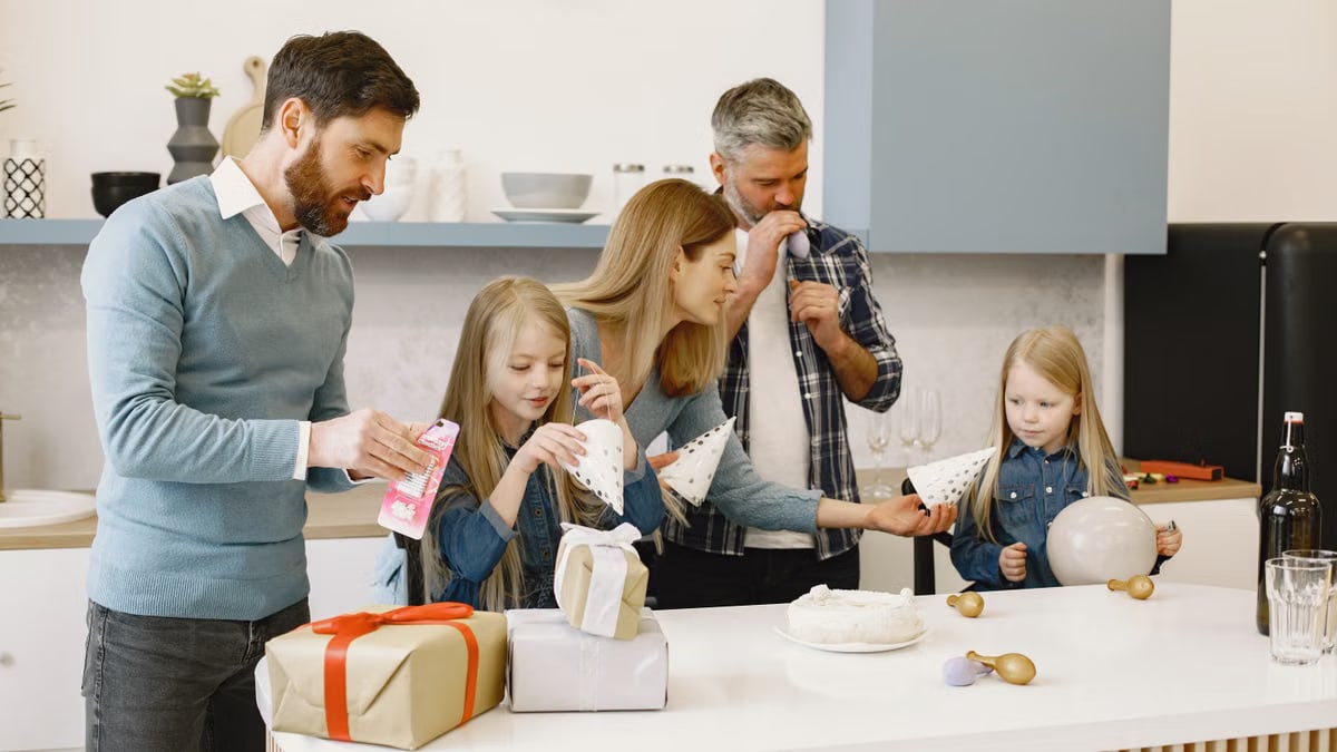 Family gathered in the kitchen setting up decorations for a birthday celebration.