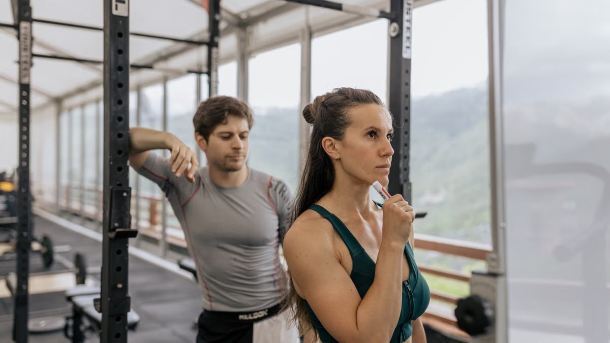 A fit couple engaged in gym exercises. Indoor workout with focus on fitness goals.